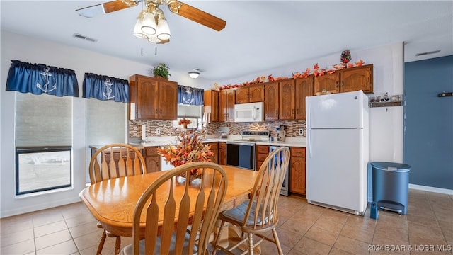 kitchen featuring ceiling fan, plenty of natural light, white appliances, and decorative backsplash