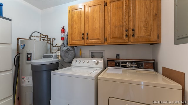 clothes washing area with electric panel, cabinets, and separate washer and dryer