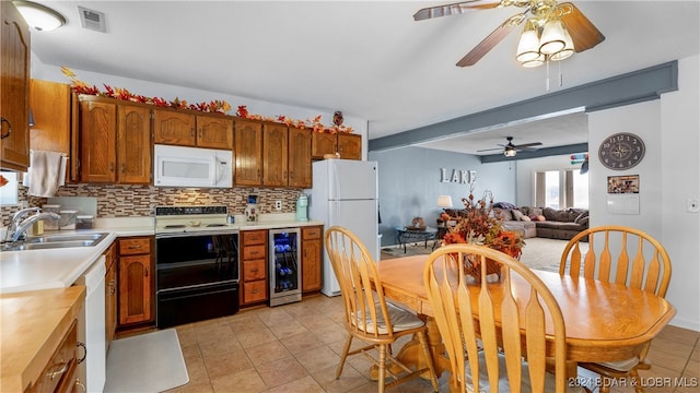 kitchen featuring wine cooler, light tile patterned floors, sink, white appliances, and tasteful backsplash