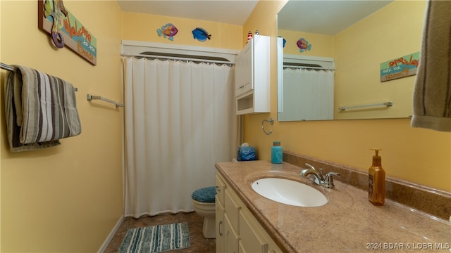 bathroom featuring a shower with shower curtain, vanity, and toilet