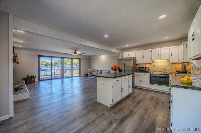 kitchen with white cabinets, a textured ceiling, stainless steel appliances, and dark hardwood / wood-style floors