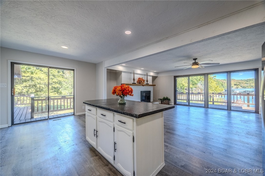 kitchen with white cabinets, ceiling fan, a textured ceiling, and dark hardwood / wood-style flooring