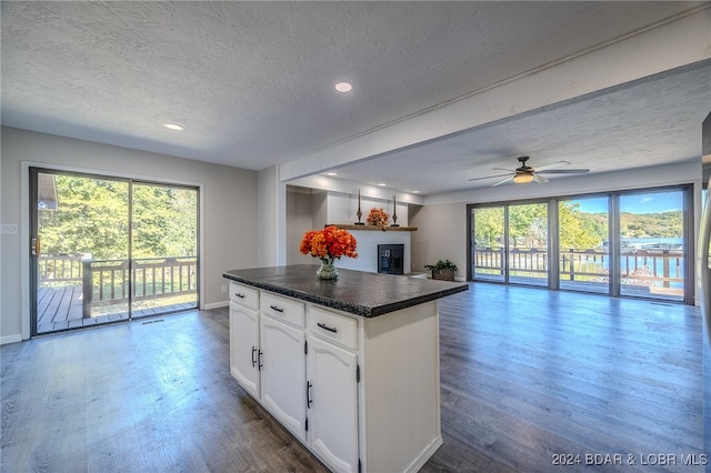 kitchen with white cabinets, ceiling fan, a textured ceiling, and dark hardwood / wood-style flooring