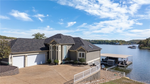 view of front of house with a dock, a garage, and a water view