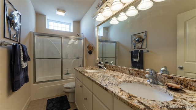 full bathroom with vanity, shower / bath combination with glass door, toilet, and tile patterned floors