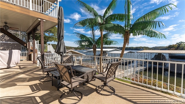 view of patio / terrace featuring a water view, ceiling fan, and a balcony