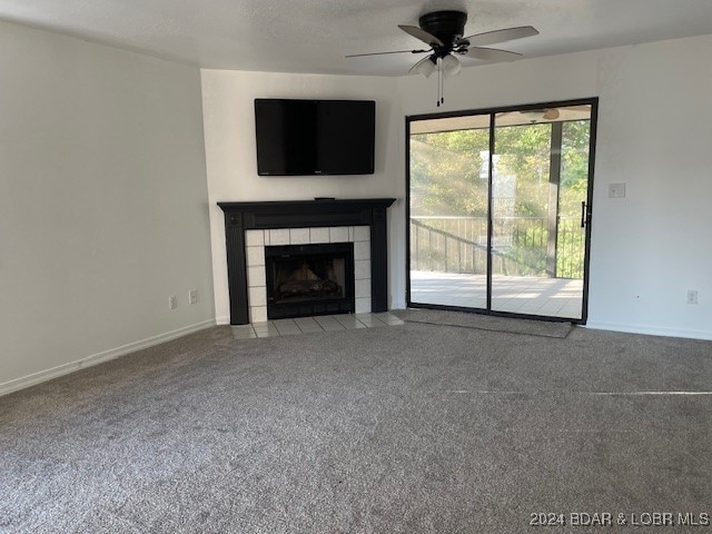 unfurnished living room with a fireplace, ceiling fan, and carpet