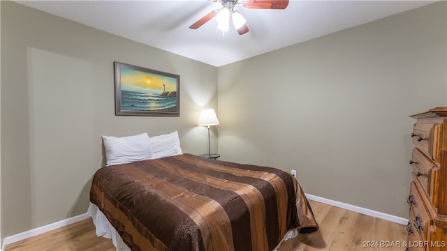 bedroom featuring a ceiling fan, baseboards, and light wood-type flooring