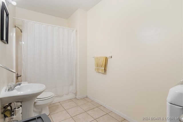 bathroom with toilet, shower / bath combo with shower curtain, and tile patterned floors