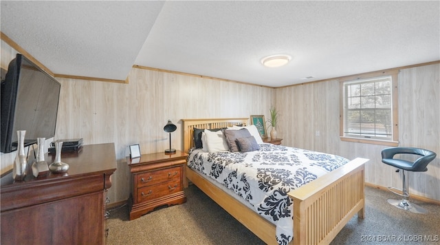 carpeted bedroom featuring wood walls and a textured ceiling