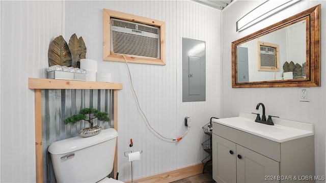 bathroom featuring vanity, toilet, an AC wall unit, and electric panel