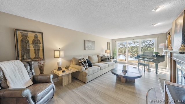 living room with light hardwood / wood-style flooring and a textured ceiling