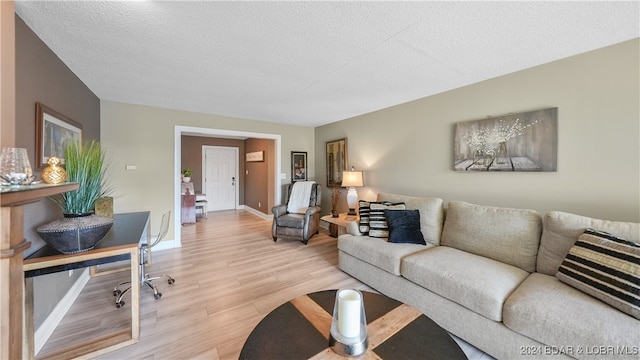 living room featuring a textured ceiling and light wood-type flooring