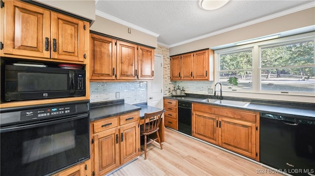 kitchen featuring decorative backsplash, black appliances, light hardwood / wood-style floors, crown molding, and sink