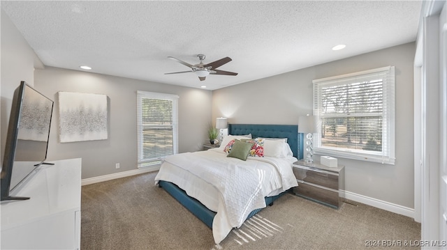 bedroom featuring carpet flooring, multiple windows, a textured ceiling, and ceiling fan