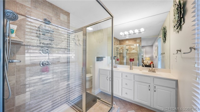 bathroom featuring vanity, toilet, walk in shower, and tile patterned flooring