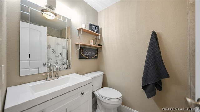 bathroom with vanity, curtained shower, and toilet