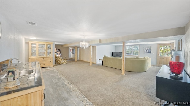 carpeted living room with a notable chandelier and sink