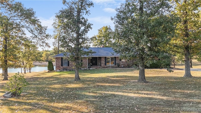 ranch-style house featuring a front yard and a water view