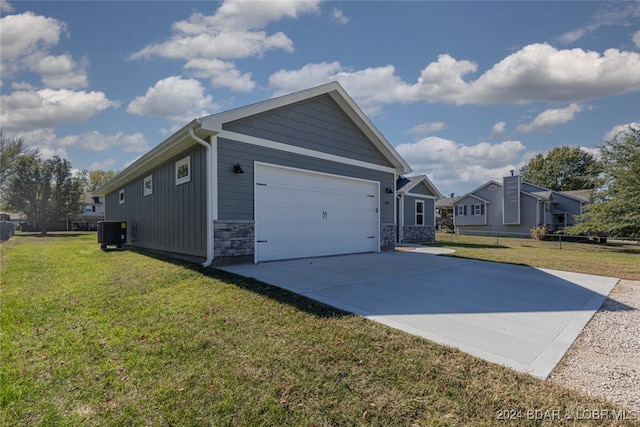 view of side of home with central air condition unit, a yard, and a garage