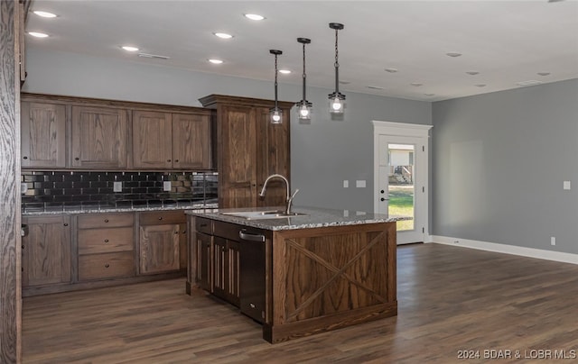 kitchen featuring dark wood-type flooring, sink, a center island with sink, and hanging light fixtures