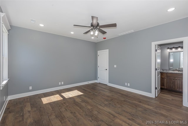 unfurnished bedroom with dark hardwood / wood-style floors, ensuite bath, sink, and ceiling fan