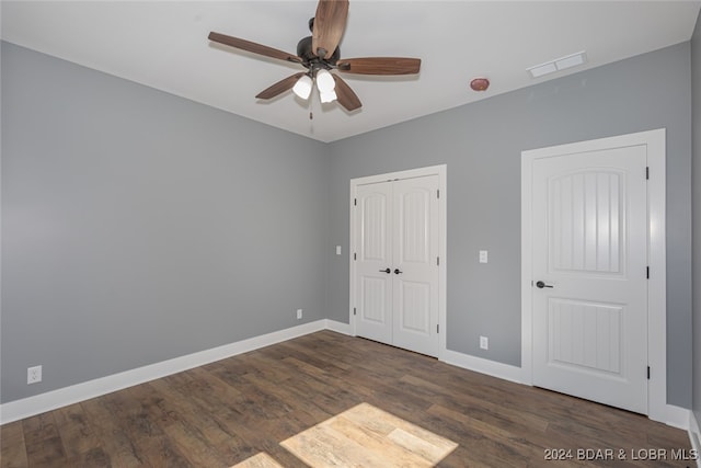 unfurnished bedroom with dark wood-type flooring and ceiling fan