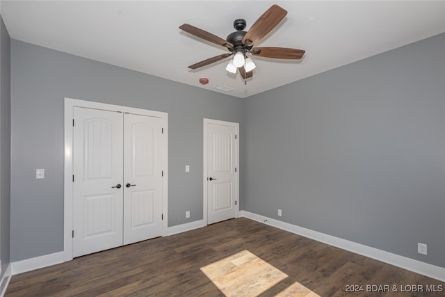 unfurnished bedroom featuring dark wood-type flooring and ceiling fan