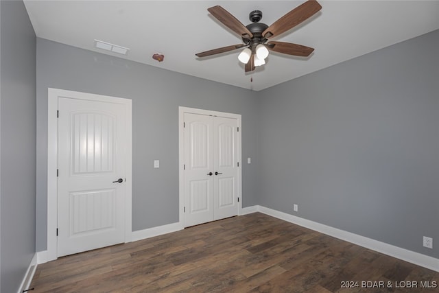 unfurnished bedroom featuring dark wood-type flooring and ceiling fan