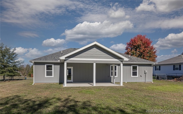 back of house featuring a patio area and a lawn