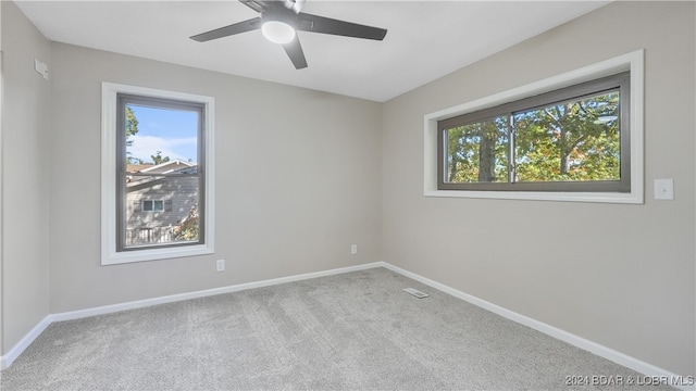 empty room with ceiling fan and light colored carpet