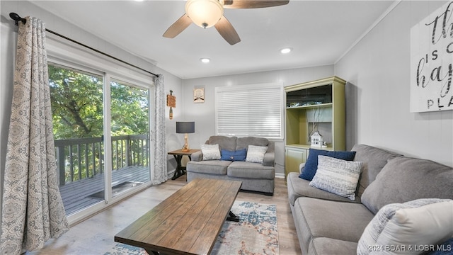 living room featuring light hardwood / wood-style flooring, ceiling fan, and ornamental molding