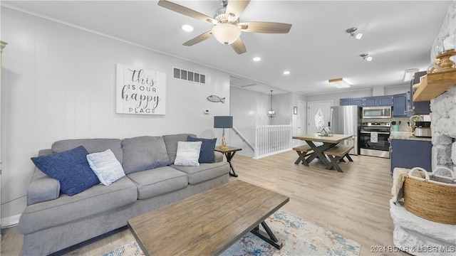 living room with ceiling fan, light hardwood / wood-style floors, and ornamental molding