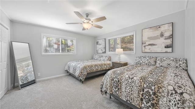 carpeted bedroom featuring multiple windows and ceiling fan