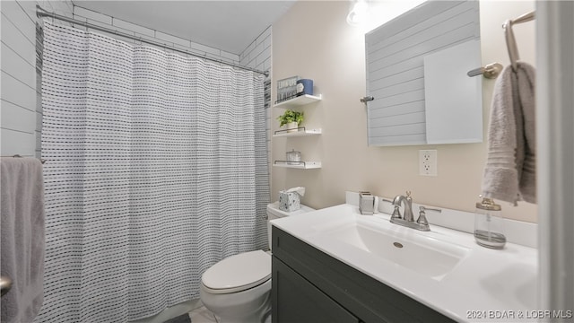 bathroom with vanity, curtained shower, and toilet