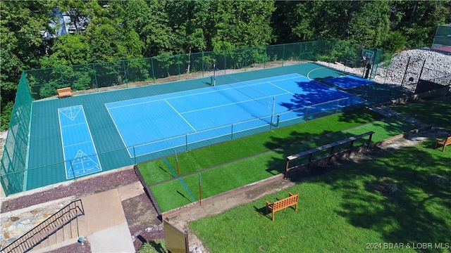 view of tennis court featuring a lawn