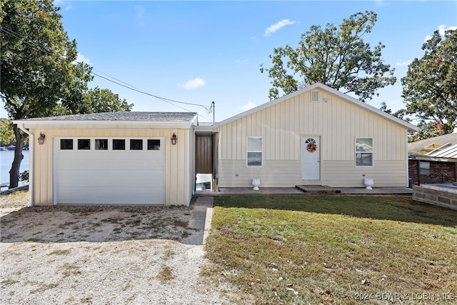 view of front of house with a front yard, an outbuilding, and a garage