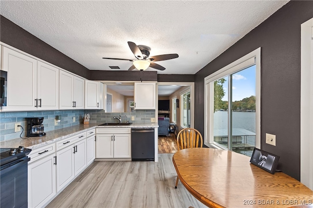 kitchen with light hardwood / wood-style floors, black appliances, light stone counters, and white cabinets