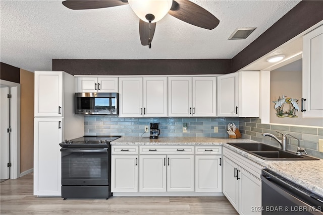 kitchen featuring black appliances, light hardwood / wood-style flooring, and tasteful backsplash