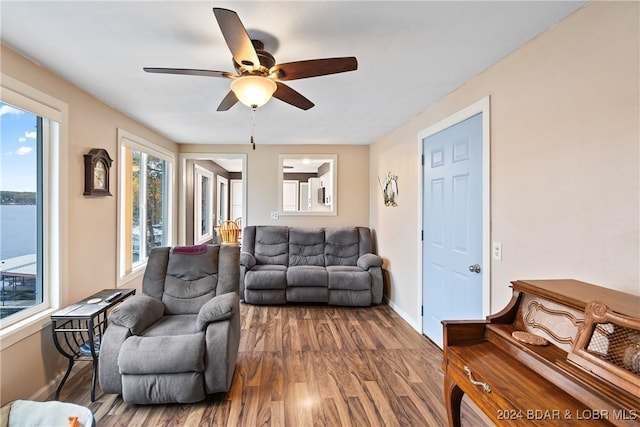 living room featuring a water view, ceiling fan, and wood-type flooring