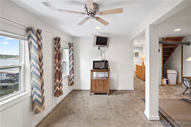 living room featuring a water view and ceiling fan