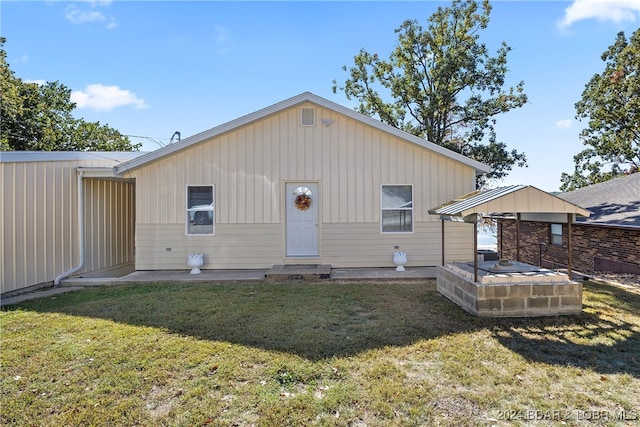 back of property with a patio area and a lawn