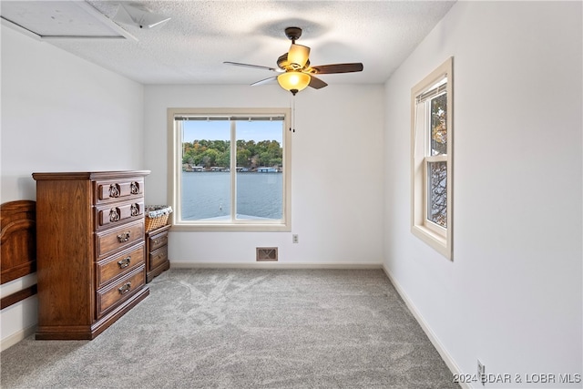 carpeted bedroom with a textured ceiling and ceiling fan