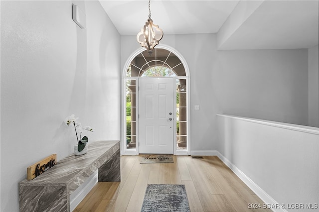 entrance foyer with light hardwood / wood-style flooring and a chandelier