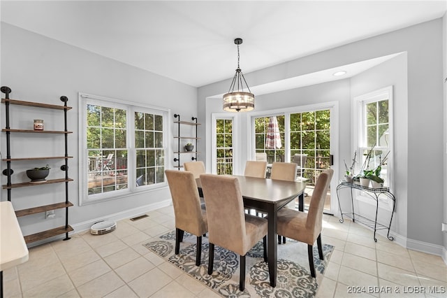 dining room with a chandelier and light tile patterned floors