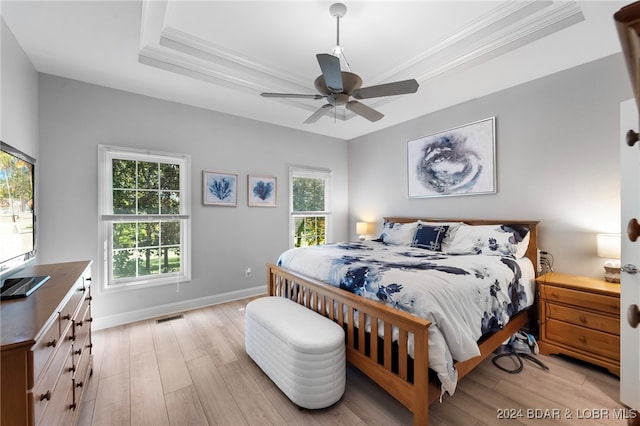 bedroom featuring multiple windows, ceiling fan, light wood-type flooring, and crown molding