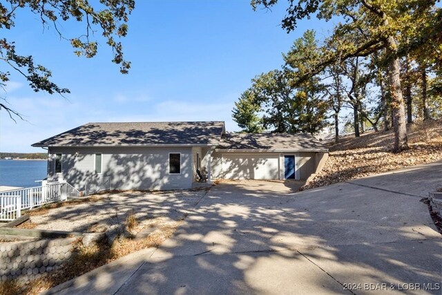 ranch-style home with a garage and a water view