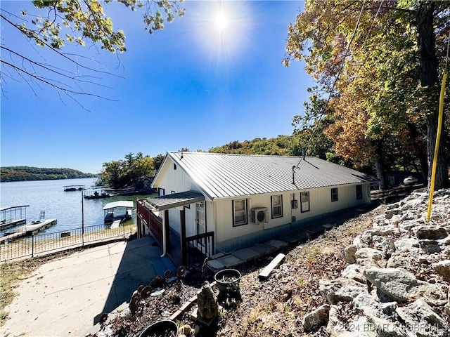 view of side of property featuring a water view and a dock