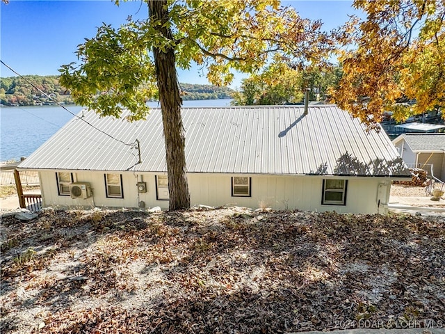 exterior space with a water view and metal roof