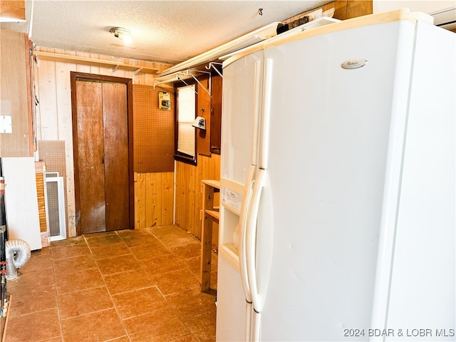 corridor with a textured ceiling and wooden walls